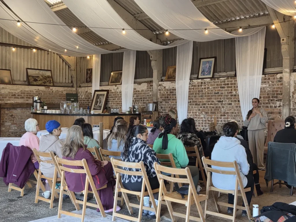 Sharon Sidhu introducing Meditation on Twin Hearts to a seated group at a wellness retreat day