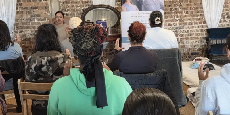 Sharon Sidhu leading a seated Meditation on Twin Hearts group at a wellness retreat day